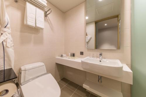 a bathroom with a sink and a toilet and a mirror at Days Hotel & Suites by Wyndham Incheon Airport in Incheon
