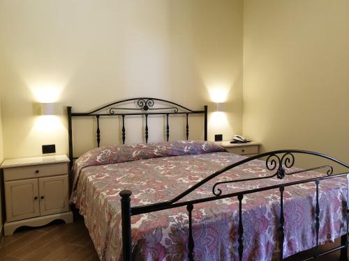 a bedroom with a bed and two night stands with lamps at Hotel Residence Il Rifugio in Palinuro