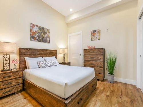 een slaapkamer met een groot bed met een houten hoofdeinde bij Stunning Apartments Close to City Attractions in New Orleans