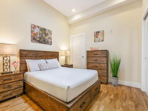 a bedroom with a large bed with a wooden headboard at Stunning Condos - Heart of NOLA - Walk Everywhere in New Orleans