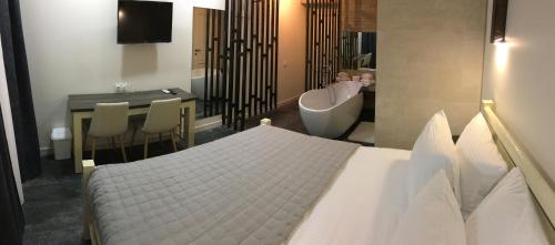 a bedroom with a bed and a tub and a bathroom at Moonlight Hotel in Chişinău