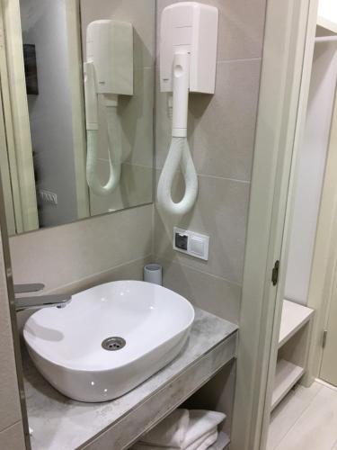 a bathroom with a white sink and a mirror at Moonlight Hotel in Chişinău