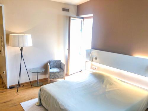 a bedroom with a bed and a chair and a window at Die Schmiede in Ybbsitz