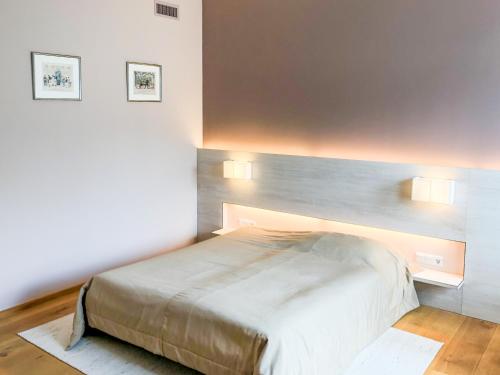 a bed in a bedroom with two lights on the wall at Die Schmiede in Ybbsitz