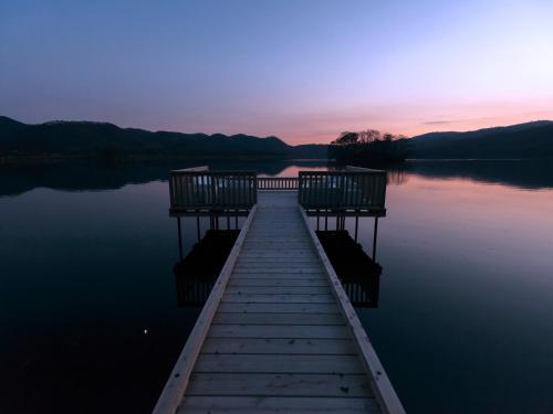 a dock on a lake at sunset at Hakodate Onuma Tsuruga Resort EPUY- 30km from Hakodate Station in Hakodate