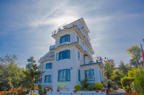 a white building with a balcony on top of it at Mount Princess Hotel in Dhulikhel