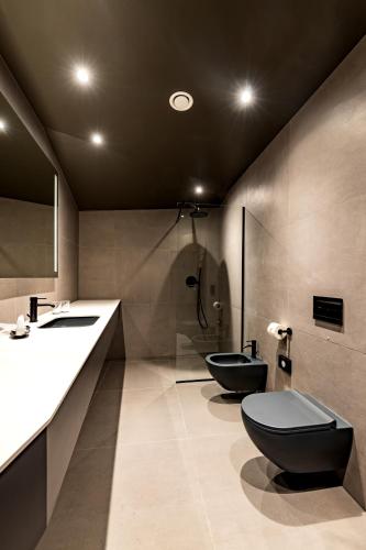 a bathroom with two sinks and two toilets at Maestro Design Hotel in Liepāja