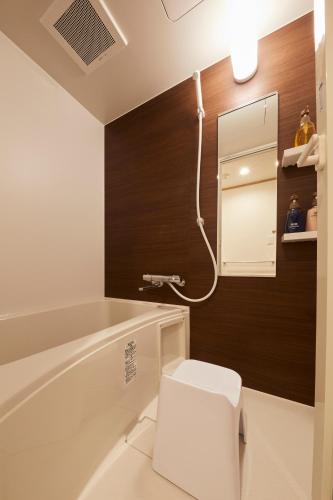 a bathroom with a toilet and a bath tub at Rinn Miyagawacho Grande in Kyoto