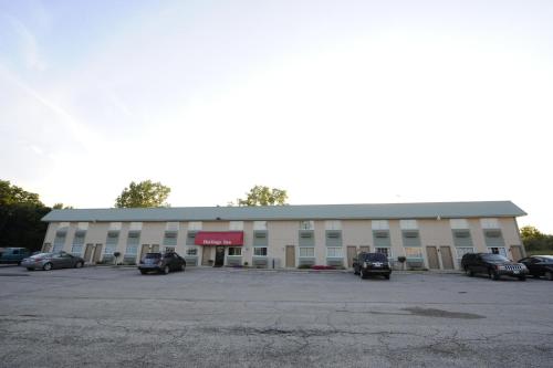 a large building with cars parked in a parking lot at Heritage Inn Mansfield in Mansfield