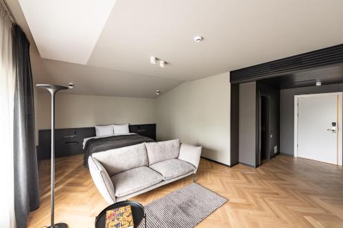 a living room with a couch and a bed at Maestro Design Hotel in Liepāja
