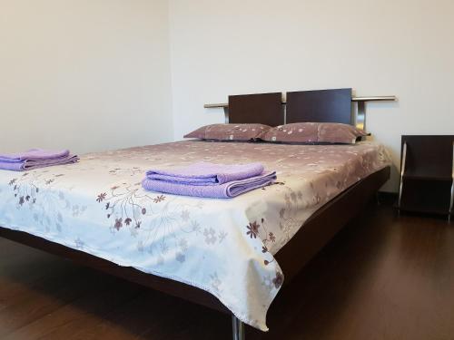 ein Bett mit lila Kissen darüber in der Unterkunft Apartament Tudor in Constanţa