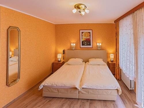 a bedroom with a large bed and a mirror at Hostellerie Val Fleuri in Mersch