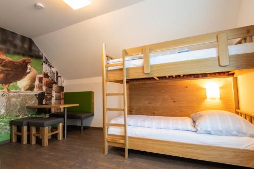 a bunk bed in a room with a desk and a ladder at Genussgasthof Willenshofer in Sankt Kathrein am Hauenstein