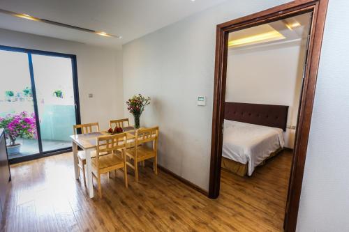 a room with a table and a mirror and a bed at Ficus Suites in Hanoi