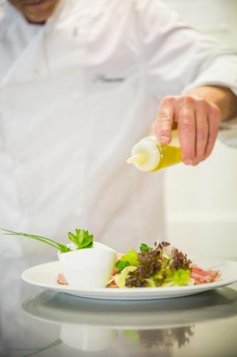 a chef is preparing a plate of food at Hotel & Restaurant Forni in Airolo