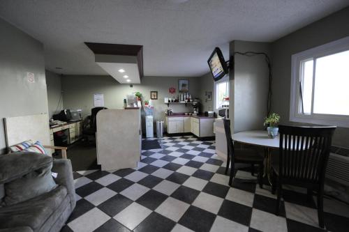 a living room with a checkered floor and a kitchen at Heritage Inn Mansfield in Mansfield