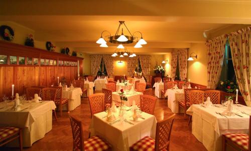 ザルツブルクにあるパノラマガストホフ ダックスリュッフの白いテーブルと椅子、シャンデリアのあるレストラン