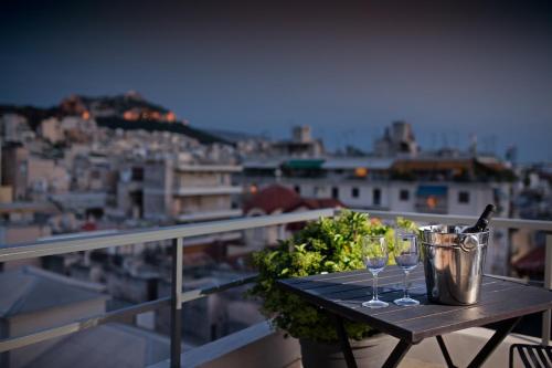 - une table avec des verres à vin et un seau sur le balcon dans l'établissement Areos, à Athènes