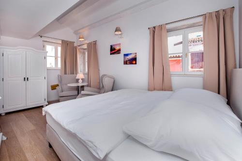a white bedroom with a large bed and a window at Casa Colloredo Free Parking in Rovinj