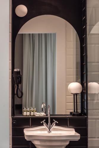 a bathroom with a sink and a mirror at Athens One Smart Hotel in Athens