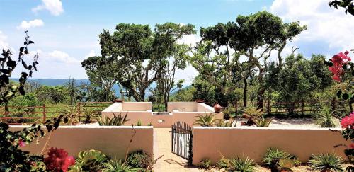 a garden with a fence and some plants and trees at Graceland Eco Retreat in Magoebaskloof