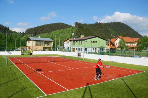 a man standing on a tennis court with a racket at Penzion Larion in Kráľová Lehota