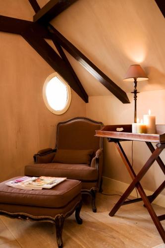 a room with a chair and a table with a lamp at Suitehotel Posthoorn in Monnickendam