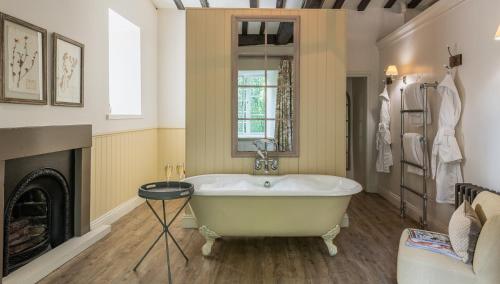 a bath tub in a bathroom with a fireplace at Lord Crewe Arms Blanchland in Blanchland