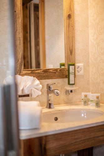 a bathroom with a sink and a mirror at Palace Luxury Wellness Apartment and Boutique Hotel Ski-in-out in Saas-Fee