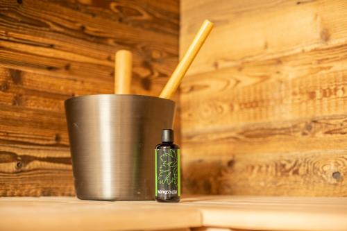 a bottle of essential oil next to a metal cup at Palace Luxury Wellness Apartment and Boutique Hotel Ski-in-out in Saas-Fee