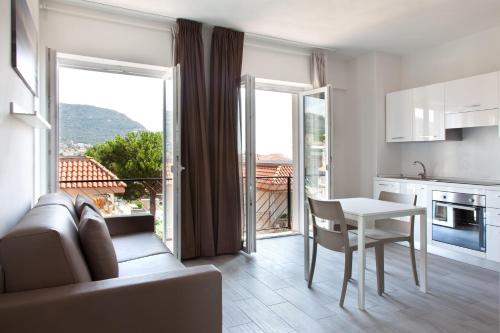 ピエトラ・リーグレにあるMiriam Hotel & Residenceのリビングルーム(テーブル付)、眺めの良いキッチンが備わります。