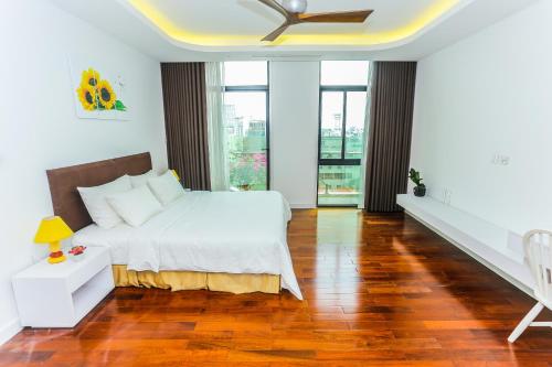 a bedroom with a bed and a ceiling fan at Ficus Suites in Hanoi