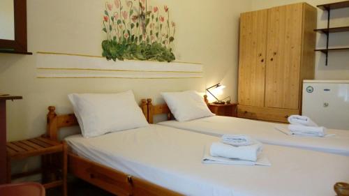 een slaapkamer met 2 bedden en handdoeken bij Kadmos in Loutra Edipsou