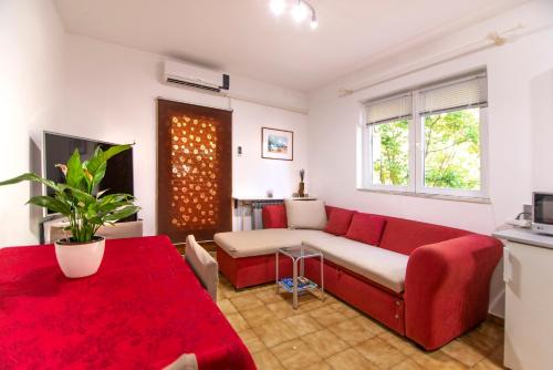 a living room with a red couch and a table at Apartments Mare in Pula