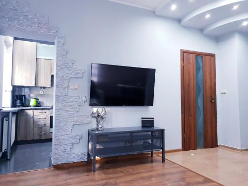 a living room with a tv on a wall at Apartament Wałbrzych / Szczawno - Zdrój in Wałbrzych