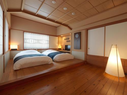 a bedroom with a large bed with two pillows at Akan Tsuruga Besso Hinanoza in Akankohan