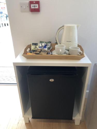 a table with a blender and two cups on it at Hamilton Arms Suites in Midhurst