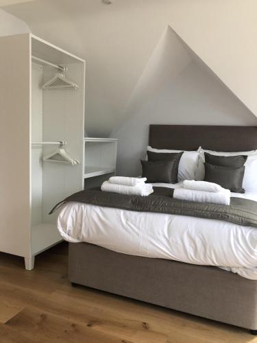 a bedroom with a large bed with white sheets at Hamilton Arms Suites in Midhurst
