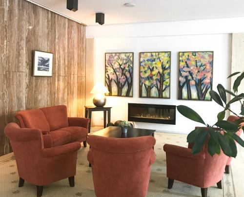 a living room with two chairs and a fireplace at HARZ HOTEL und Gästehaus am Bornweg in Bad Sachsa