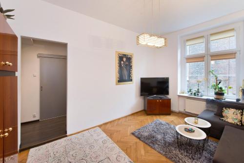 a living room with a couch and a tv at Studio Lawendowa in Gdańsk