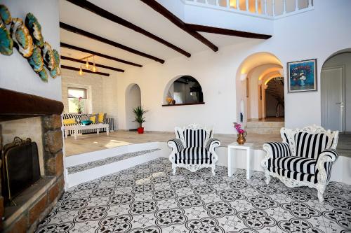 a living room with two chairs and a fireplace at Flag Suites +12 in Bodrum City