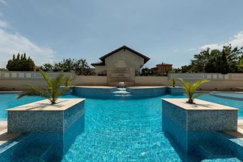 a swimming pool with two palm trees in the water at Penelopa Palace Apart Hotel & SPA in Pomorie