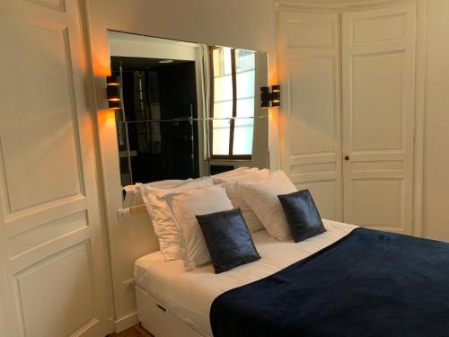 a bedroom with a bed with two pillows and a mirror at La suite Marilyn in Rouen