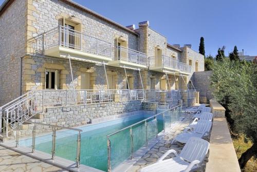 a building with a swimming pool next to a house at Manoleas Villas- Apartment 1 in Stoupa