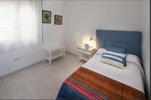 een slaapkamer met een groot bed met een blauw hoofdeinde bij La Merced RooMalaga by Bossh! Apartments in Málaga