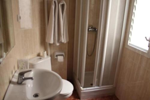 y baño con lavabo, ducha y aseo. en Pension Americano, en Almería