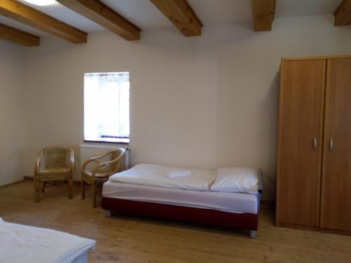 a bedroom with a bed and a cabinet and a window at Žabonosy Mlýn in Žabonosy
