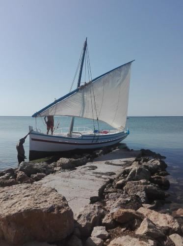 a boat sitting on the shore of the ocean at Casa Mia in Ouled Kacem