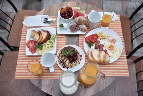 a table topped with plates of breakfast foods and drinks at Prior Hotel in Prizren