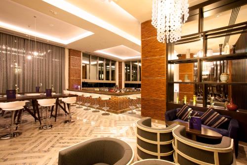 un restaurant avec un bar doté de chaises et d'un lustre dans l'établissement Kaya Palazzo Golf Resort, à Belek